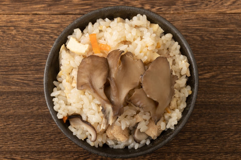 Maitake mushroom in a bowl of rice on a wooden table